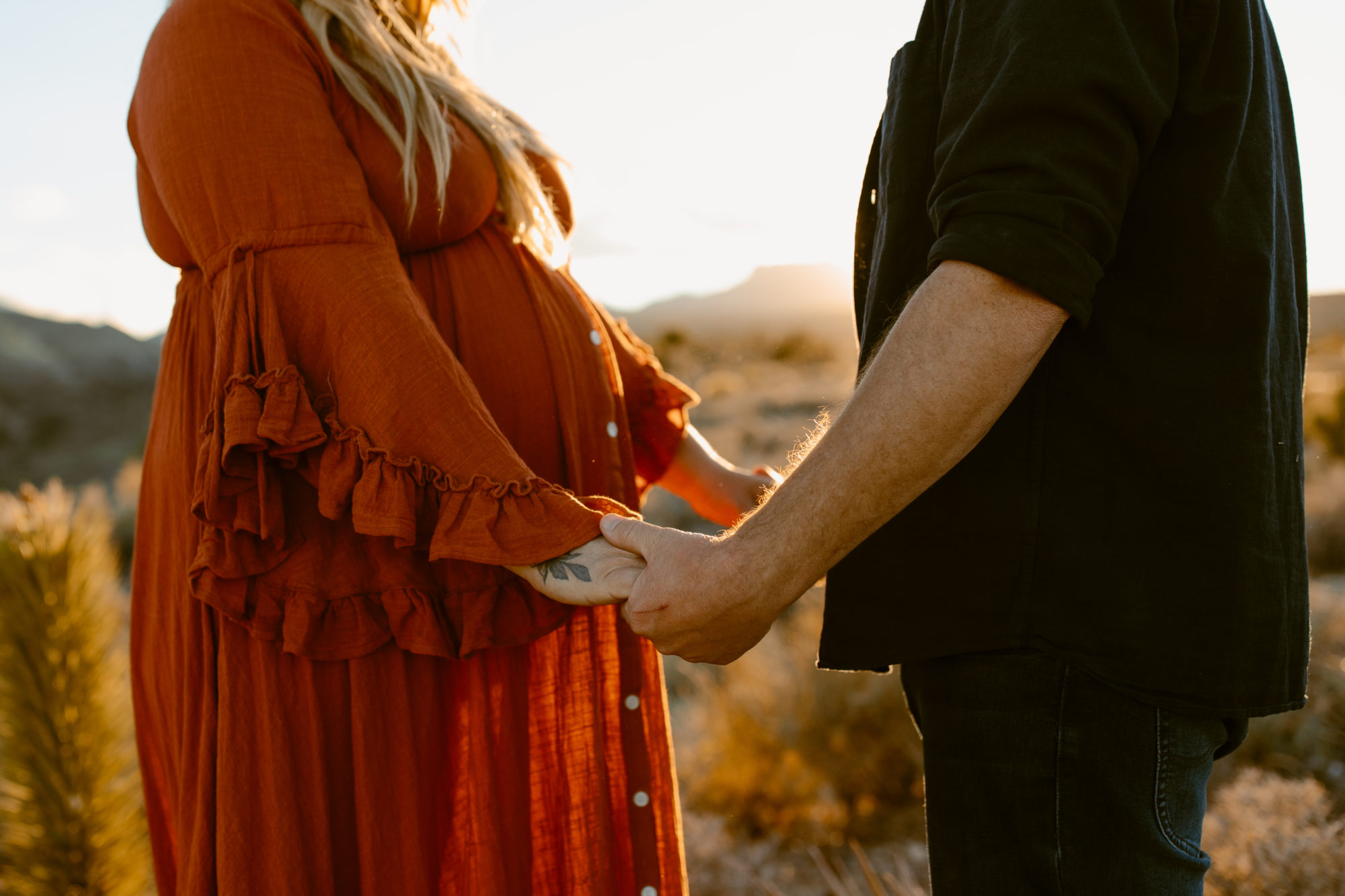 Man and woman posing for maternity photoshoot in the desert 
