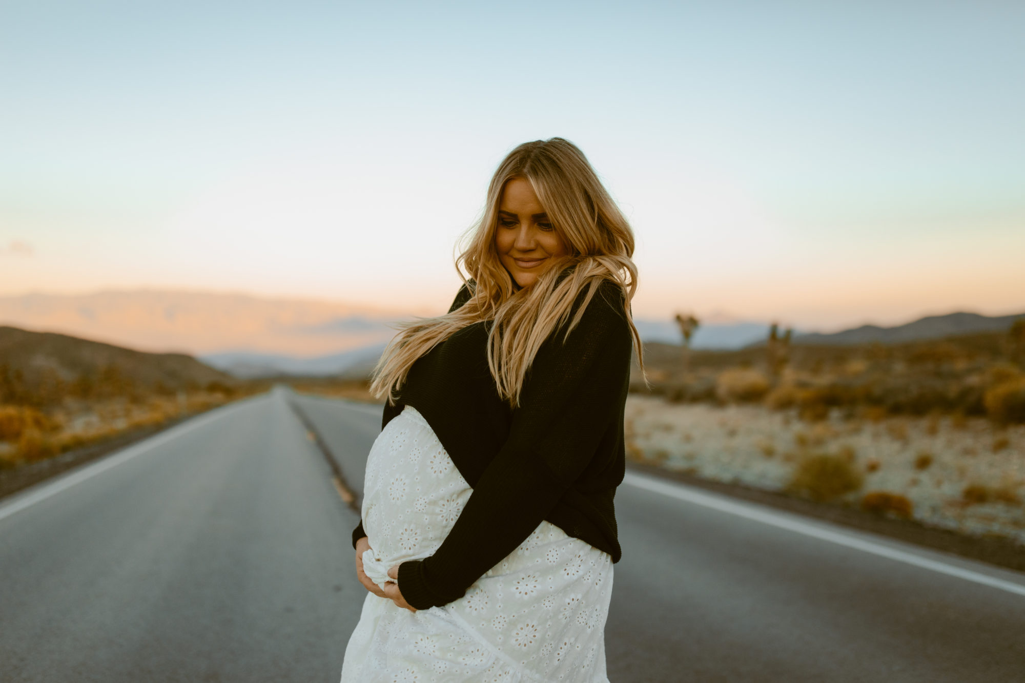 Woman holding belly for desert photoshoot 