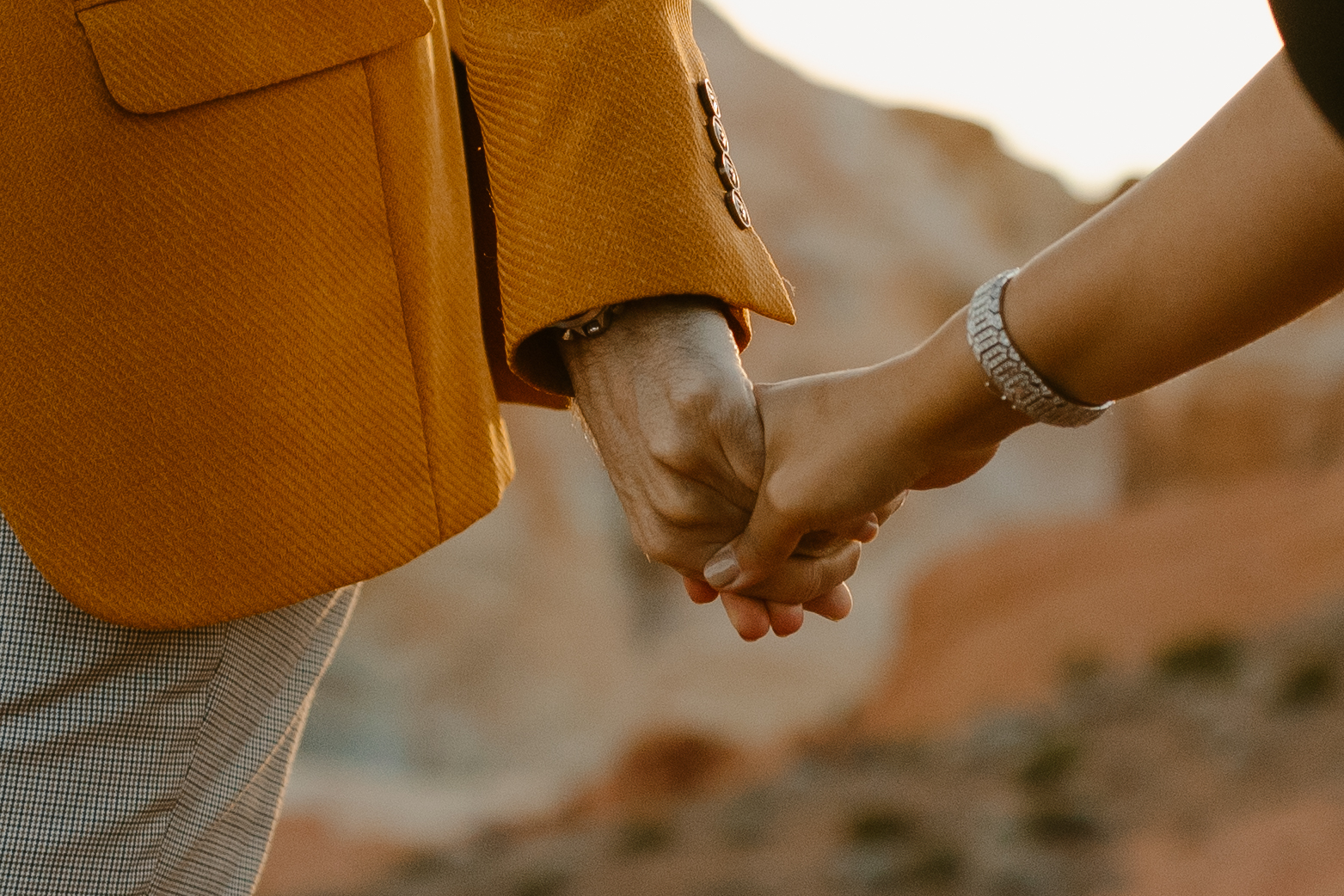 Couple holding hands in the desert during photoshoot