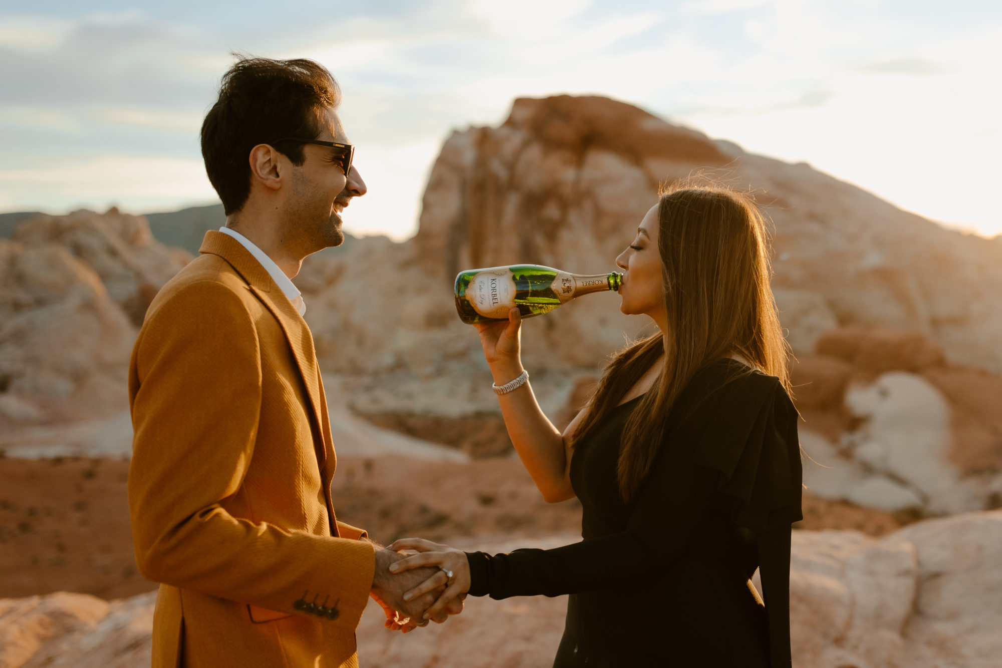 Couple drinking chapagne after desert photoshoot