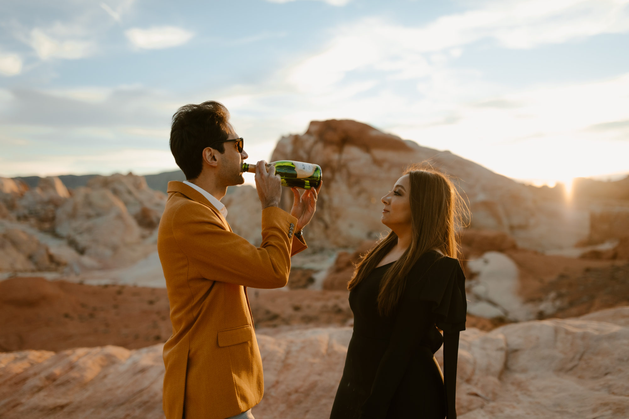 Couple drinking chapagne after desert photoshoot